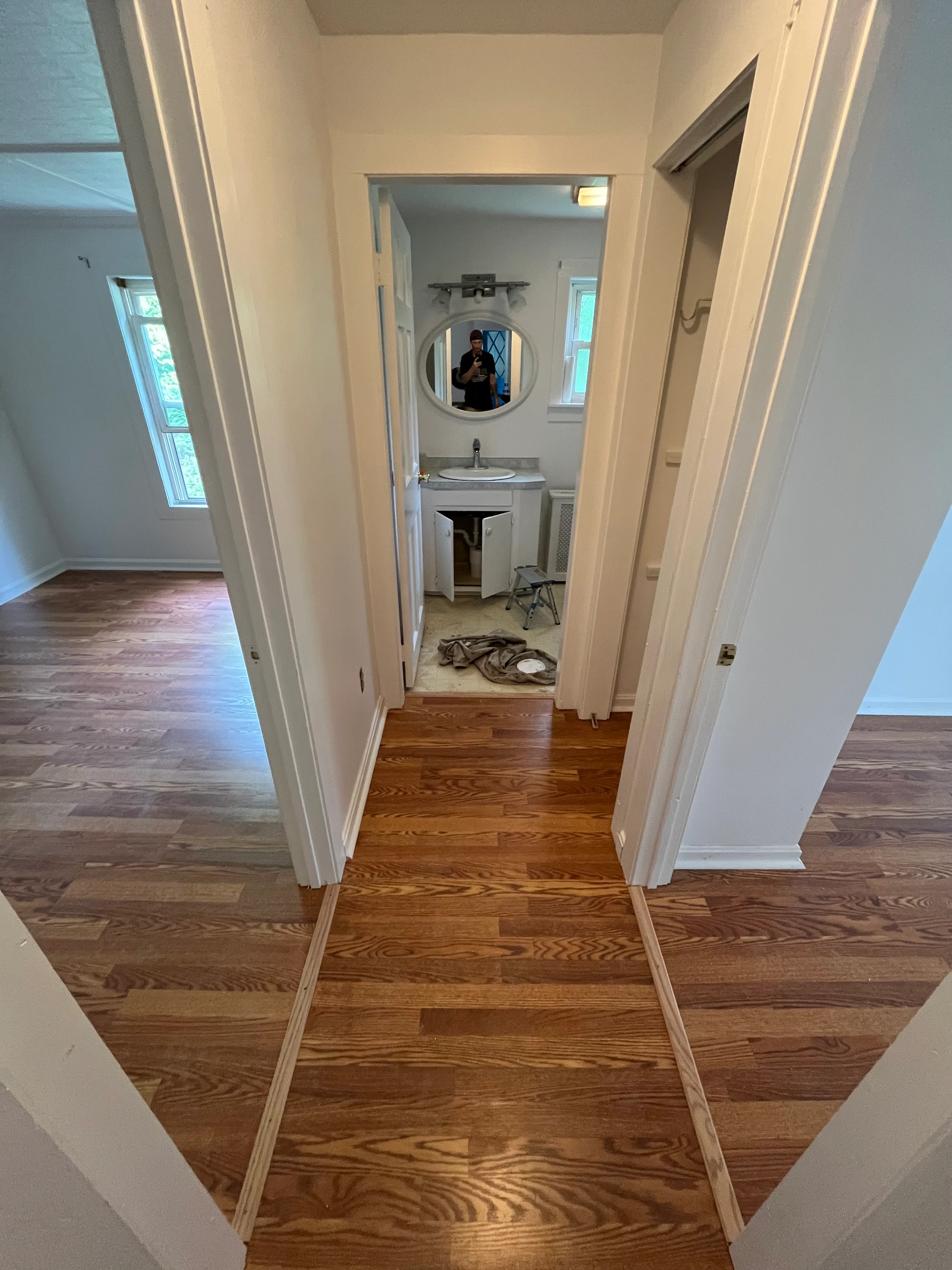Completed bathroom view showing vanity, mirror, and lighting