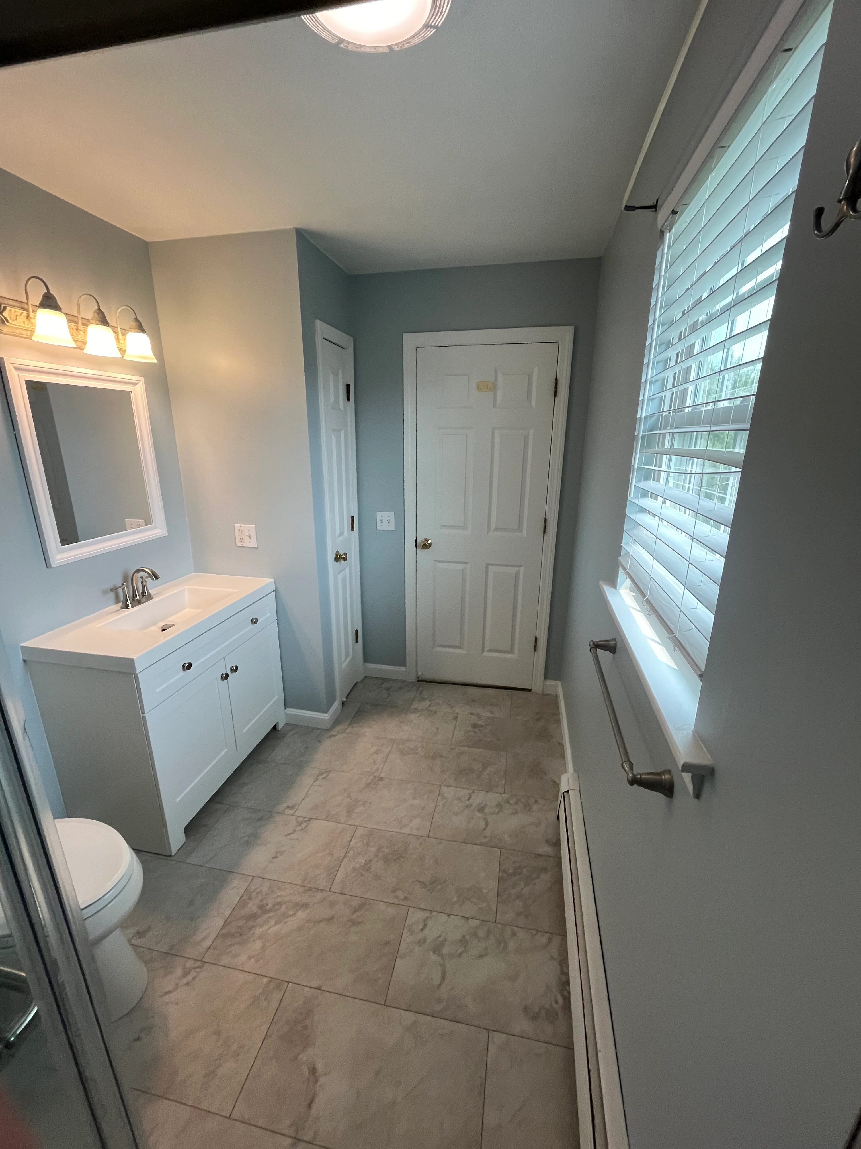 Completed bathroom with hex floor tile and blue vanity