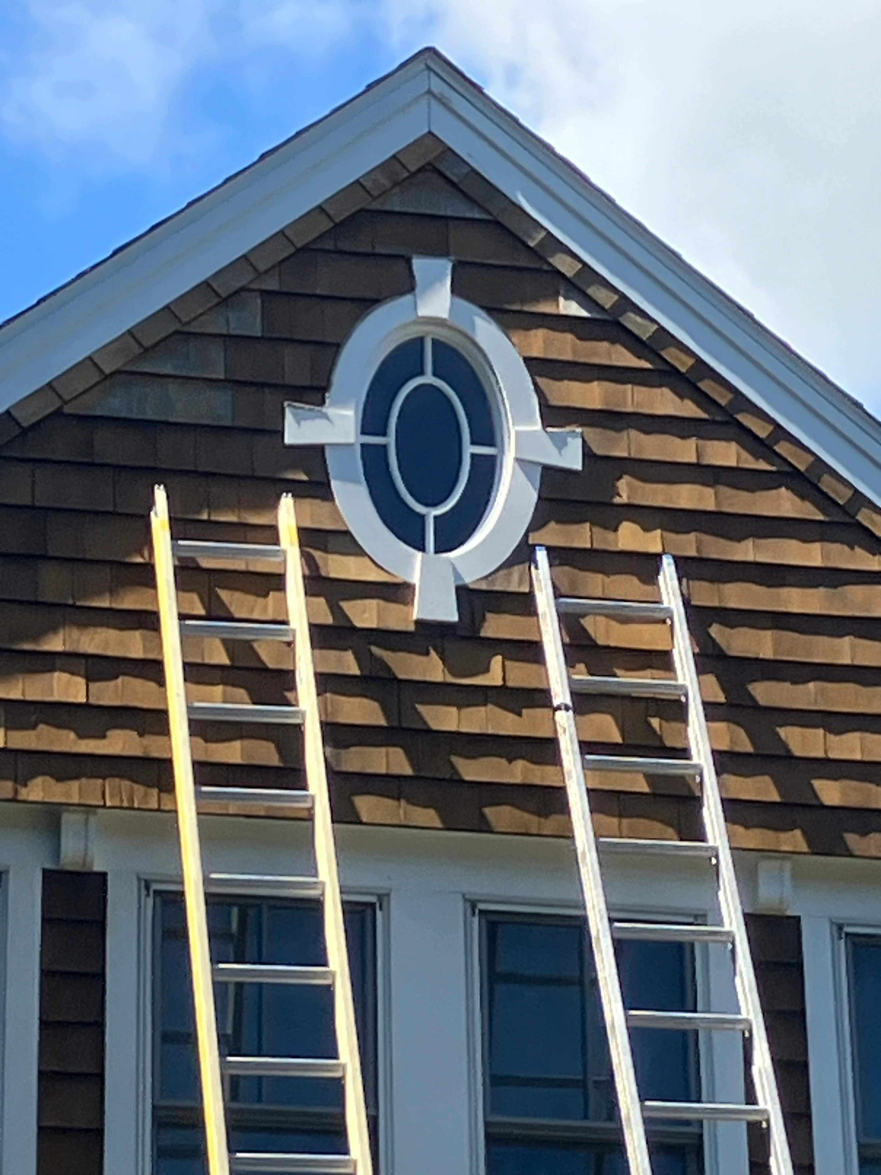 Completed cedar shake gable with restored oval window trim