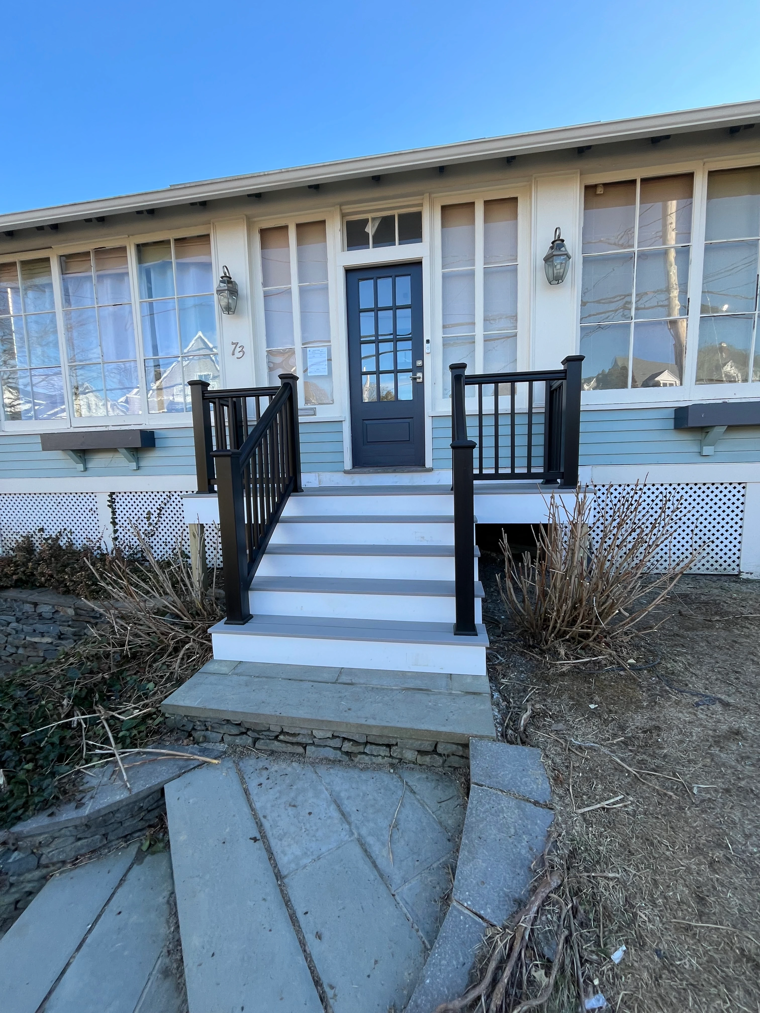 Restored front entrance porch with new railing and white door